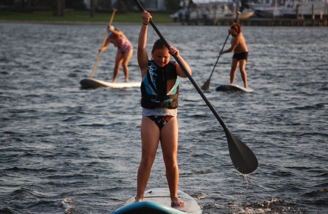 nina y dos senoras navegando en paddle surf